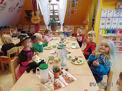 Verkleidete Kinder essen gemeinsam