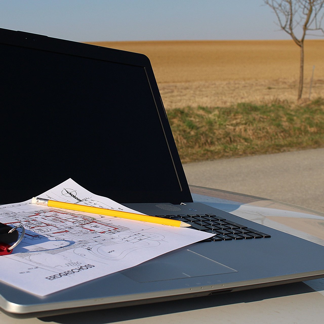 Laptop mit Bauplan auf einer Baustelle