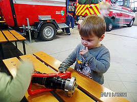Ein Kind schaut sich Feuerwehrequipment an