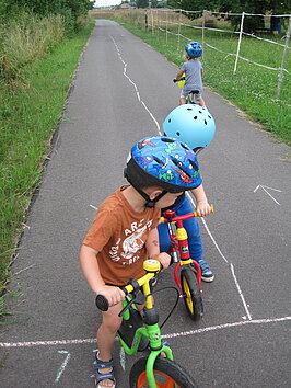 Kinder mit Helm auf Fahrrädern