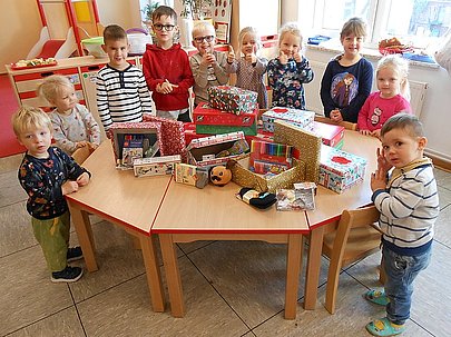 Kinder versammelt um einen Geschenketisch