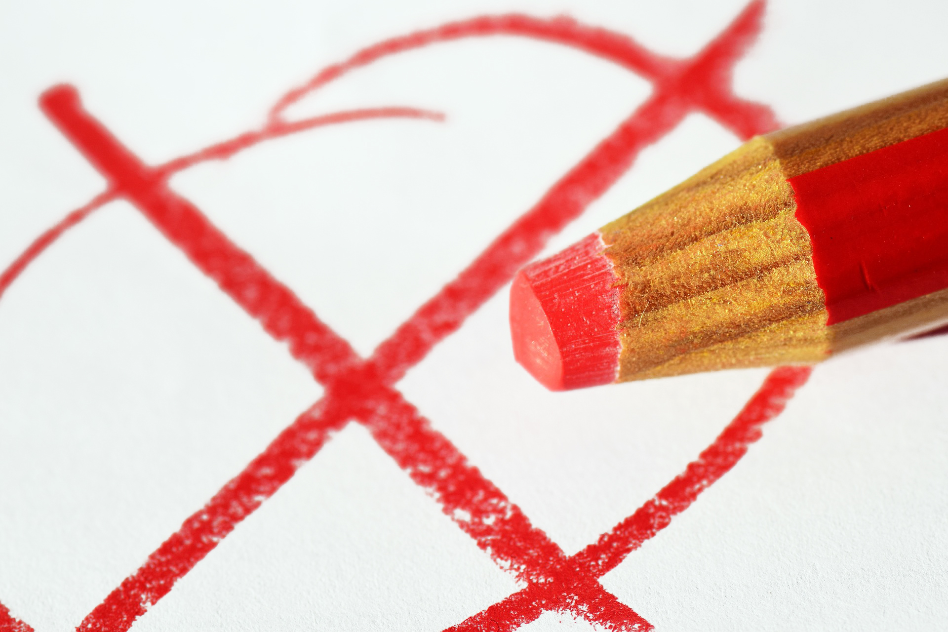 Roter Buntstift und rotes Kreuz