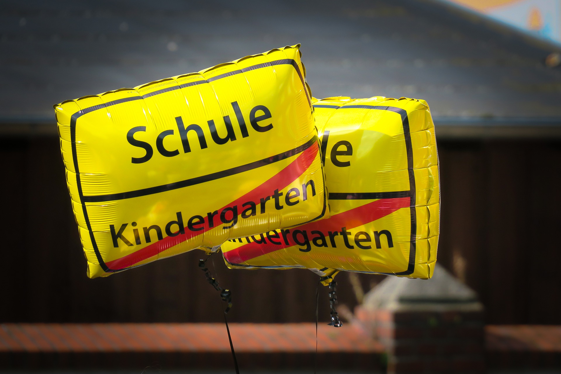 Luftballons mit dem Wort Schule und dem durchgestrichenen Wort Kindergarten